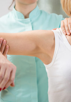 Physical therapist diagnosing patient with painful arm