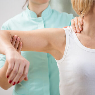 Physical therapist diagnosing patient with painful arm